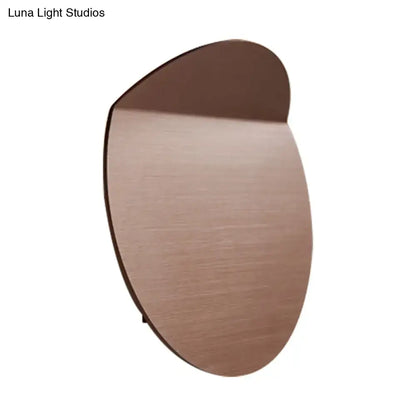 A sleek oval minimalist copper sconce light with brushed finish wall mount and energy-saving led bulb for bedroom use