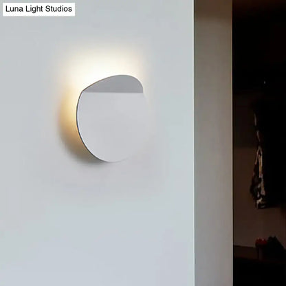 Minimalist white circular wall mount sconce light with a sleek modern design featuring an led bulb for bedroom use