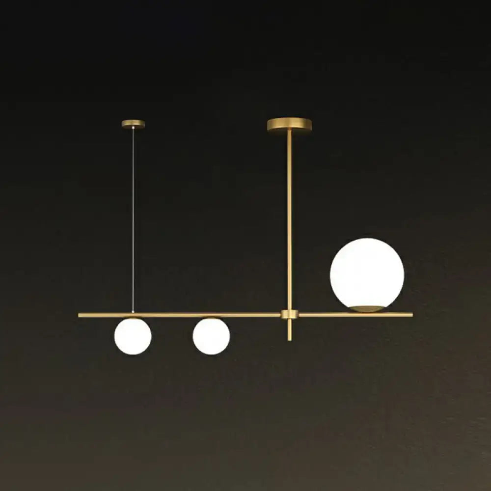 Modern brass pendant light with three cream glass spherical bulbs for dining room globe island illumination