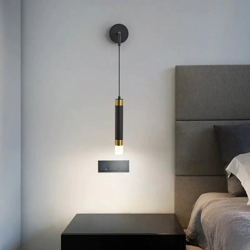 Minimalist creative luxury black cylindrical pendant light with gold accents and warm glow for luxury bedroom bedside