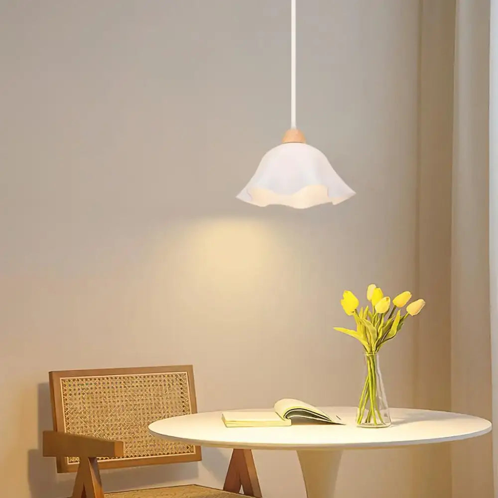 Minimalist pendant light with a crisp white petal-shaped glass shade and wood accent for kitchen island lighting