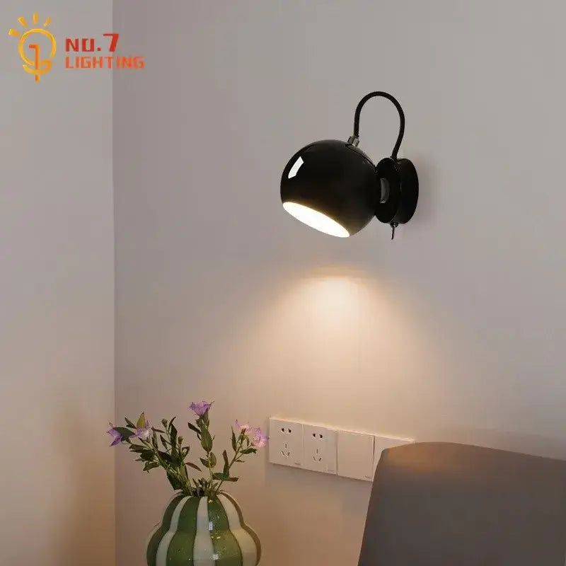 Black matte-finished wall lamp with curved arm and adjustable head in decorbites cream wind led bedroom collection
