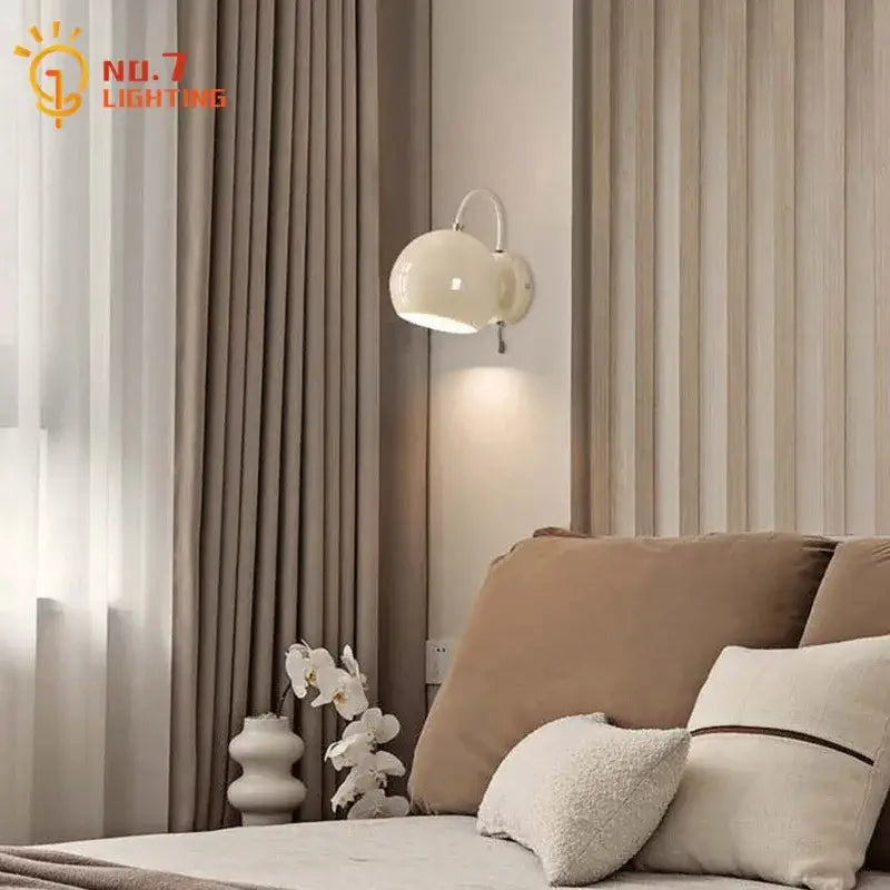 Minimalist decorbites cream wind led wall lamp with a cream spherical shade and curved metallic arm for bedroom