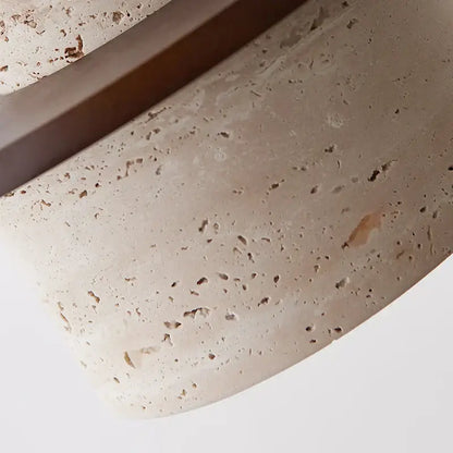 Beige textured stone surface with subtle speckles and smooth curved edge of decorbites led yellow travertine pendant lamp