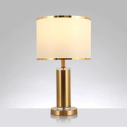 Decorbites minimalist fabric cylinder table lamp with gold-finished brass nightstand base and off-white drum shade