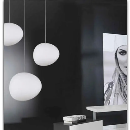 Three white frosted glass egg-shaped pendant lights complement minimalist decorbites cobblestone wall lamp design