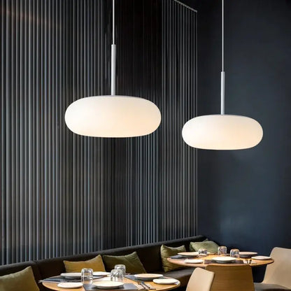 Two minimalist pendant lamps with frosted white glass shades and slender metallic rods for dining table decorbites itka pendant lamp