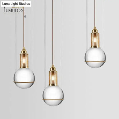 Three elegant gold-toned hanging lamps with crystal globe shades for minimalist living room decor by decorbites