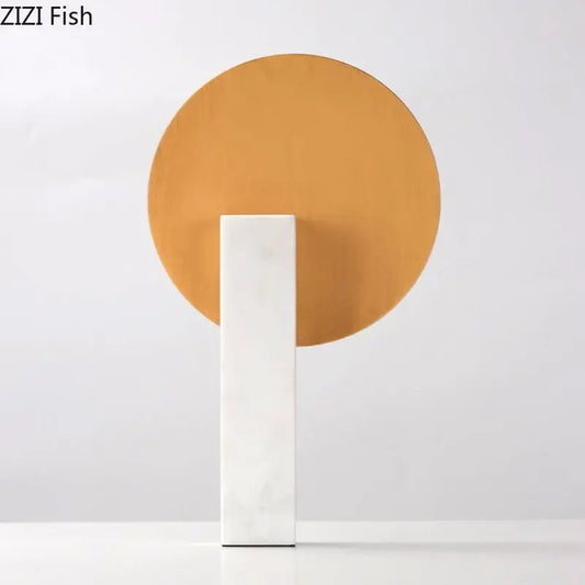 Minimalist desk decoration featuring a white marble base and a golden circular disc for modern living room decor