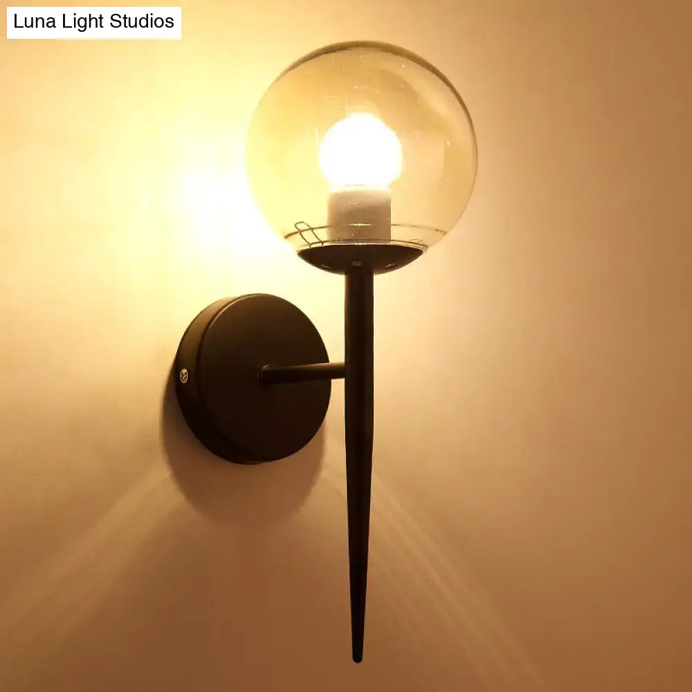 Minimalist black metal wall sconce with a clear glass globe and pencil arm, featuring an illuminated e26 e27 bulb