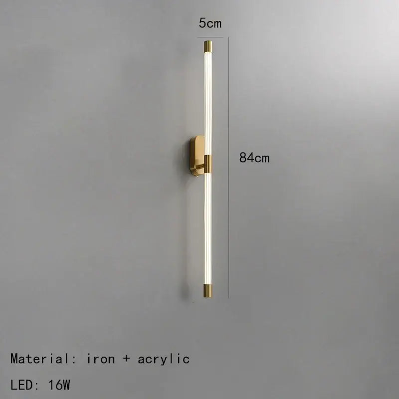 A sleek minimalist gold and black decorbites acrylic line led wall light with brass iron base and acrylic diffuser tube
