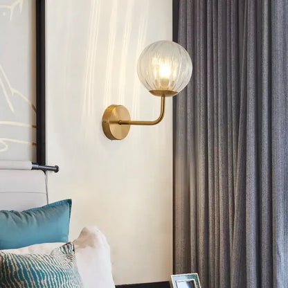 Minimalist gold and black glass ball led wall lamp with gold-toned sconce and textured translucent globe for decorbites