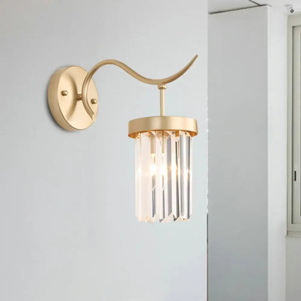 Minimalist gold wall mount light featuring a curved arm and vertical crystal prisms for bedroom decor