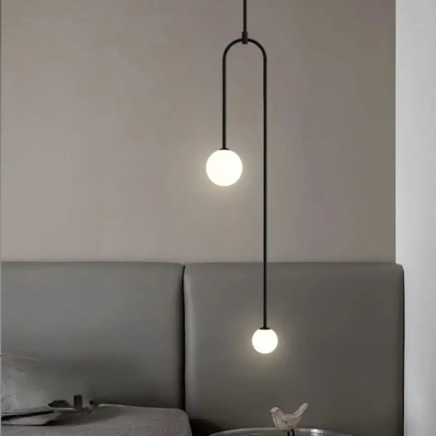 Black minimalist pendant lights with double head glass ball frosted bulbs and curved metal arm for bedroom use