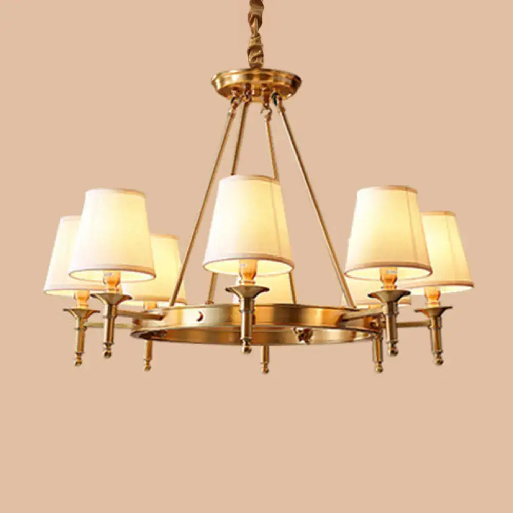Brass-finished minimalist conical ceiling chandelier with six cream fabric bedroom shades for elegant lighting