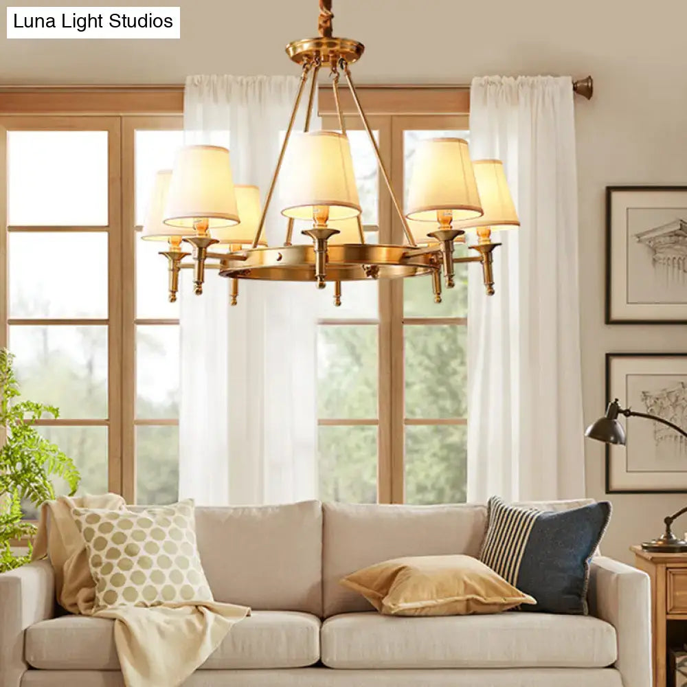 Brass minimalist conical ceiling chandelier with six cream-colored fabric shades for fabric bedroom lighting