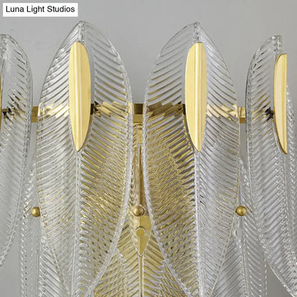 Minimalist gold finish crystal leaf wall sconce featuring clear ribbed glass feather design with polished gold accents