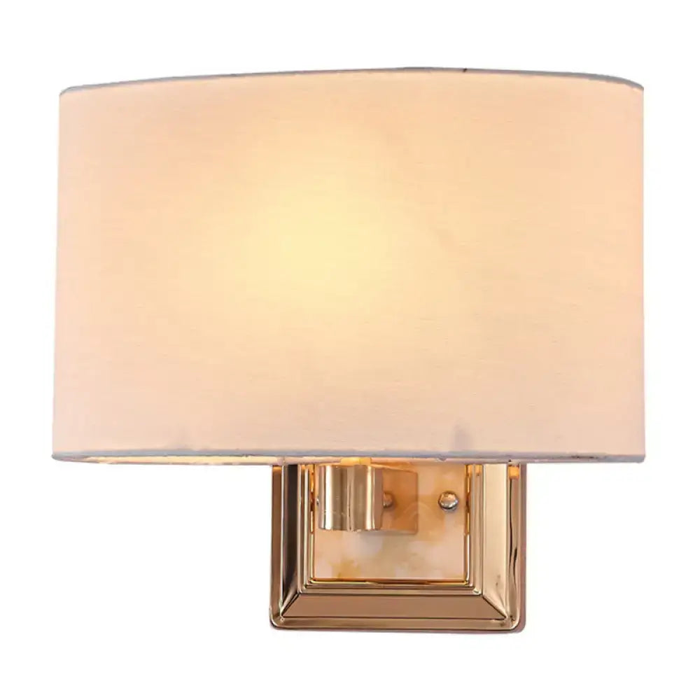 Minimalist gold finish rectangular wall sconce with a soft off-white fabric shade for dining room lighting