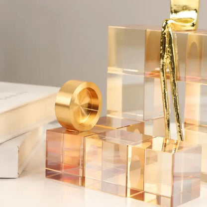 Minimalist gold geometric stair crystal ornament with a polished reflective metallic ring on transparent acrylic decorbites cubes