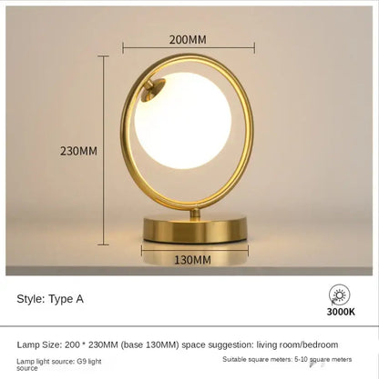 Minimalist gold-toned table lamp with glass ball led bulb encased in metallic ring for bedroom decorbites decor