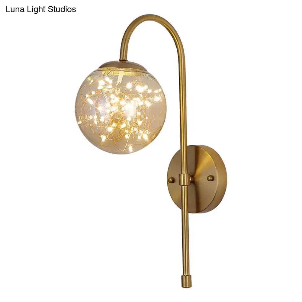 Minimalist wall light with brass gooseneck arm and smoke gray amber globe housing warm fairy lights for bedroom