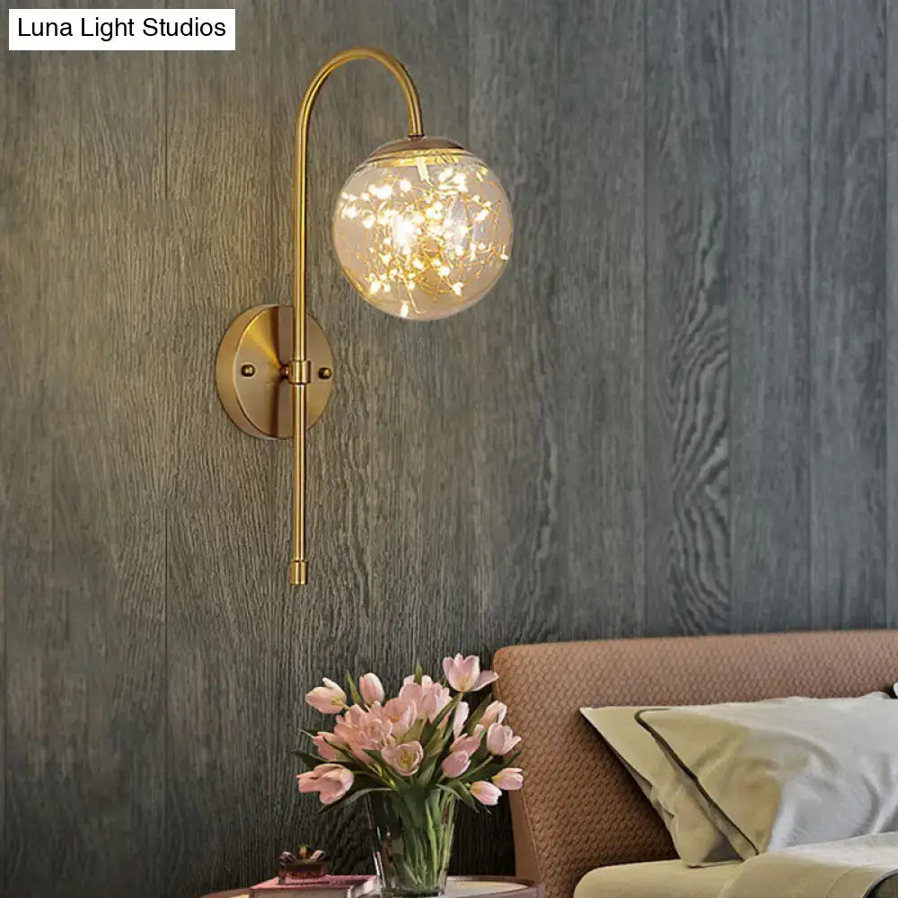 Minimalist gold gooseneck wall light with smoke gray amber spherical glass globe and fairy lights for bedroom use