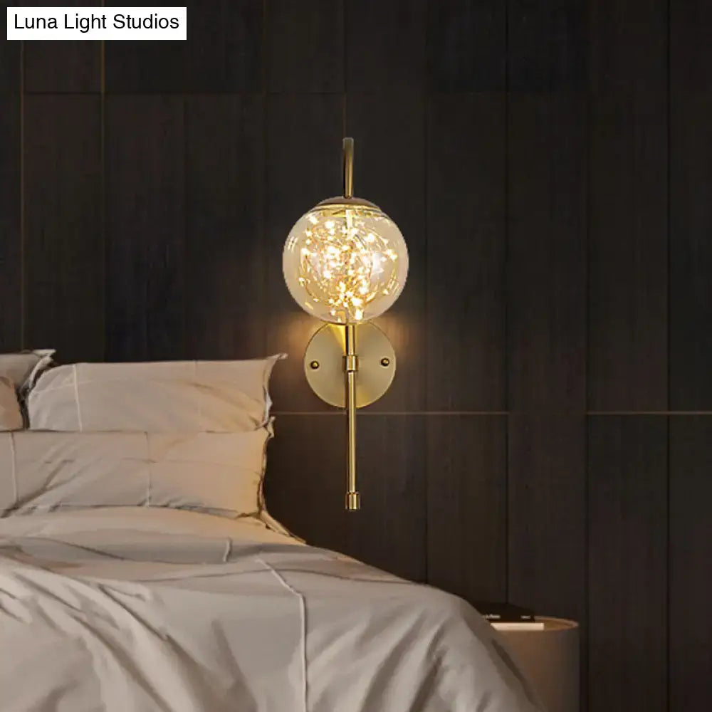 Minimalist gold gooseneck wall light with smoke gray amber glass globe and warm fairy lights for bedroom use
