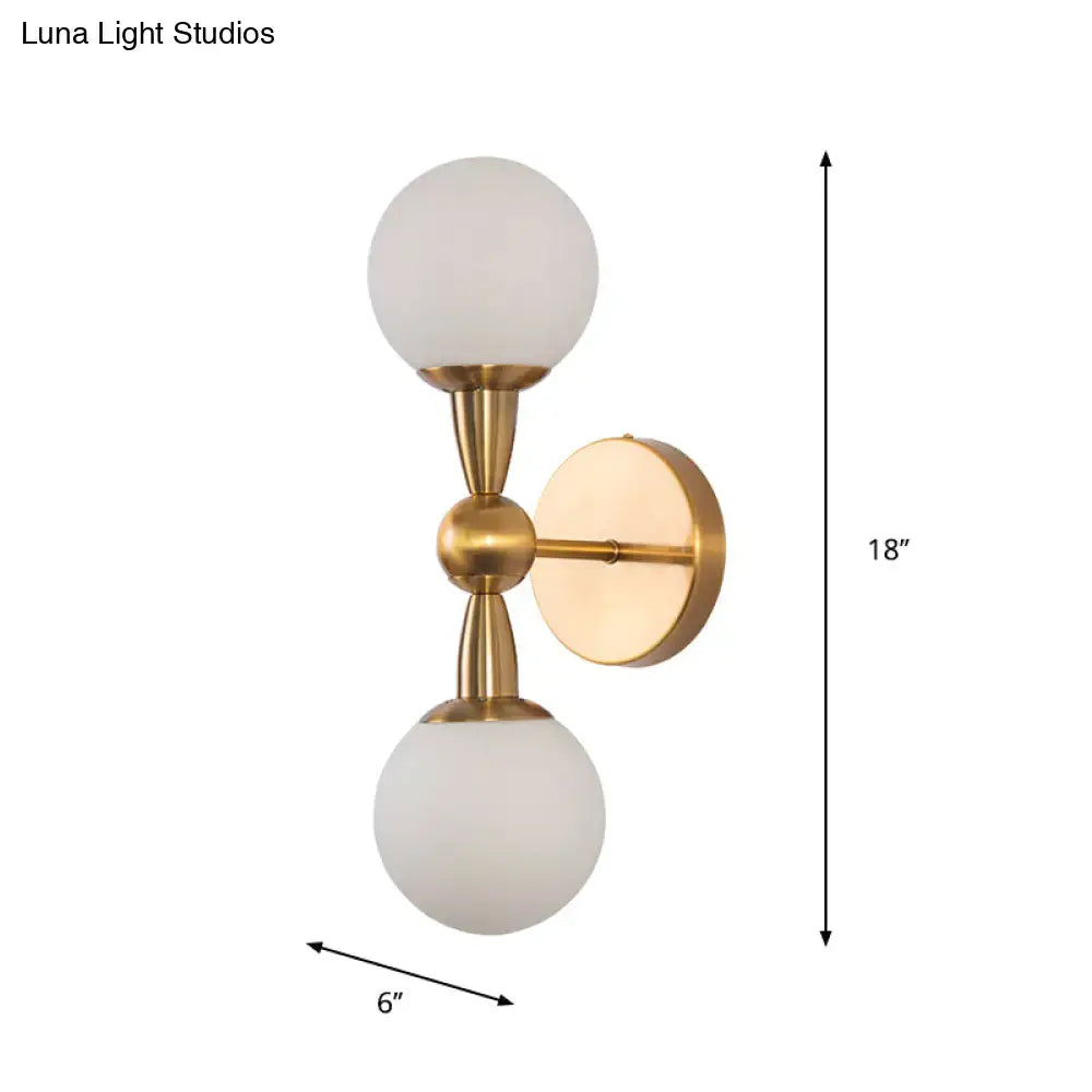 Minimalist gold hand blown glass wall sconce with two frosted globe shades for bedroom sconce light