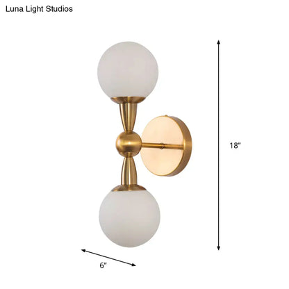 Minimalist gold hand blown glass wall sconce with two frosted globe shades for bedroom sconce light