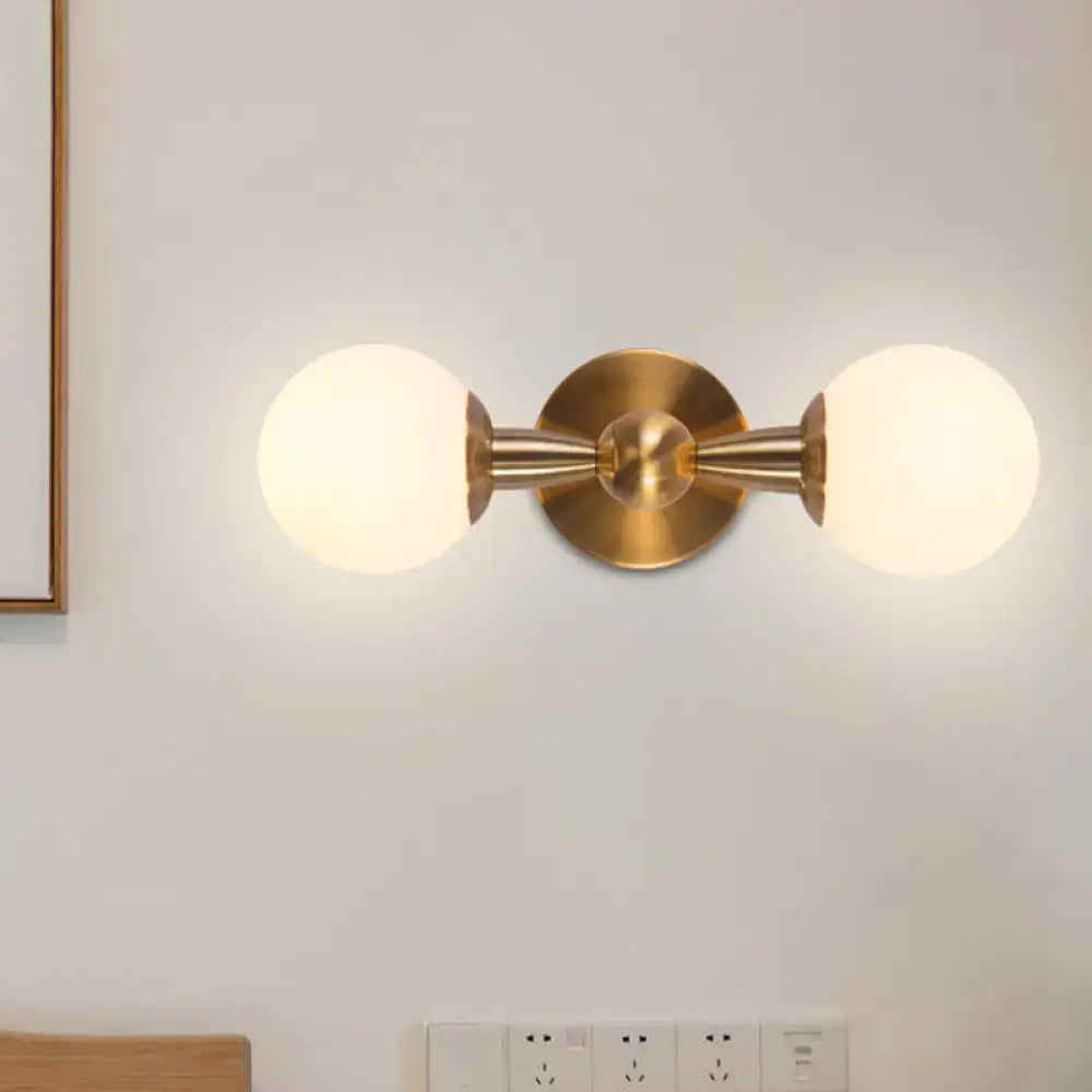 Minimalist gold wall sconce light with hand blown glass frosted globe shades for bedroom lighting