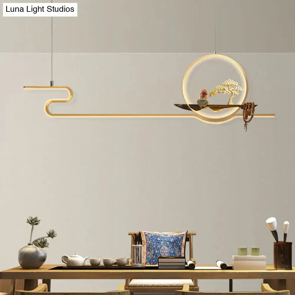 Minimalist gold linear hanging lamp with circular frame, sculpted bonsai tree, and adjustable chain cord length for study room