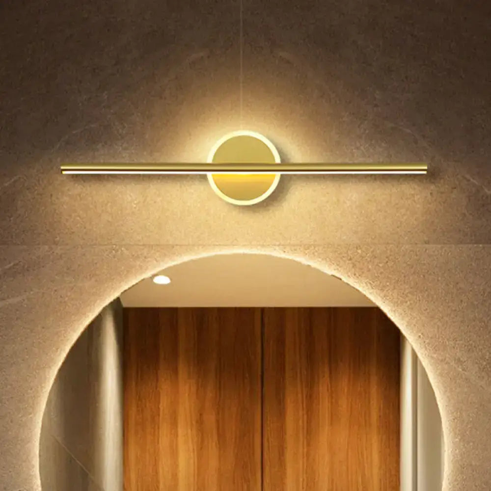 Minimalist gold linear led wall sconce with a circular illuminated center and warm ambient light for modern wall sconce use