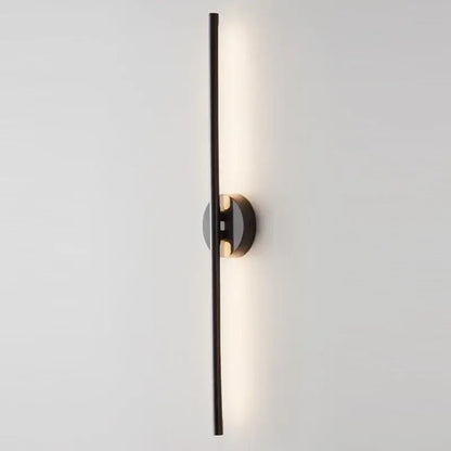 Black minimalist wall sconce lamps with a sleek vertical bar and circular base emitting warm ambient light