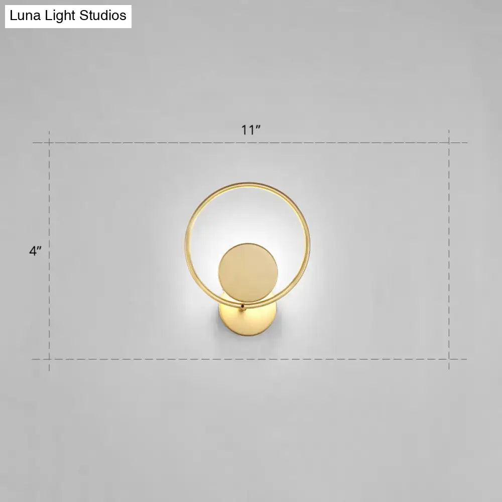 Minimalist gold metal led sconce wall mounted lamp featuring a circular ring and concentric disc design for bedroom use
