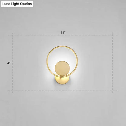 Minimalist gold metal led sconce wall mounted lamp featuring a circular ring and concentric disc design for bedroom use