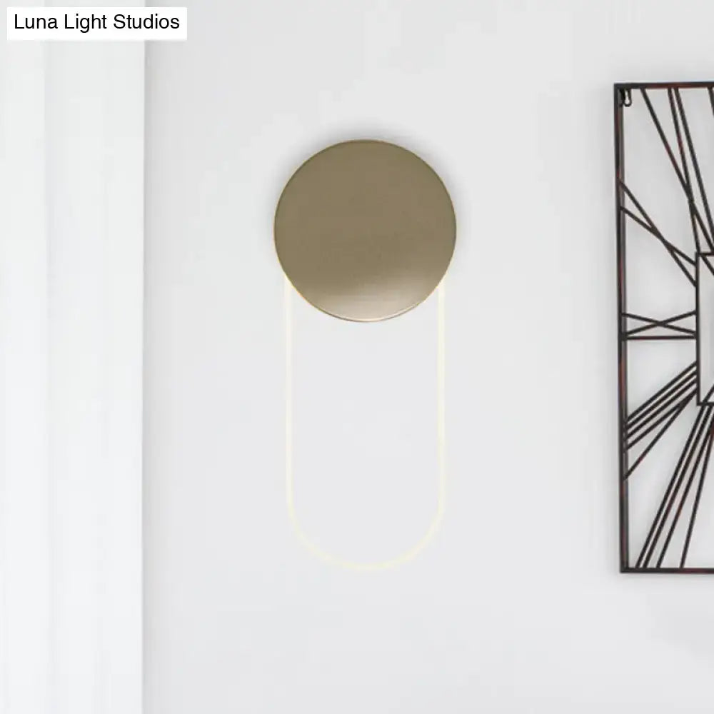 Minimalist gold metal wall lamp with a sleek brushed gold circular head and curved led light fixture for bedroom use