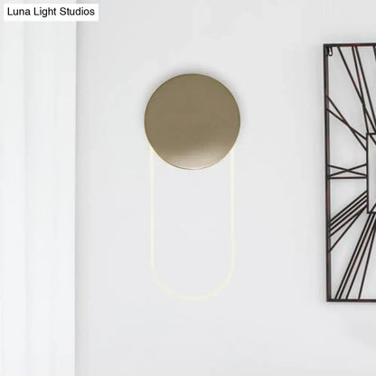 Minimalist gold metal wall lamp with a sleek brushed gold circular head and curved led light fixture for bedroom use