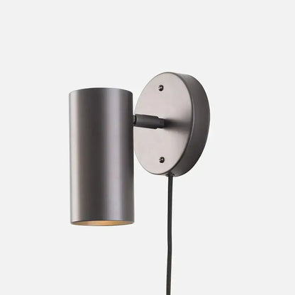 Matte-finished dark gray cylindrical bedside spotlight wall lamp with circular backplate and black cord bulb base