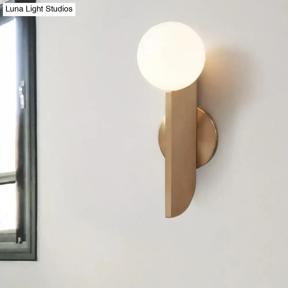 Modern brass-finished gold mini globe wall sconce with a spherical frosted glass bulb for bedroom lighting