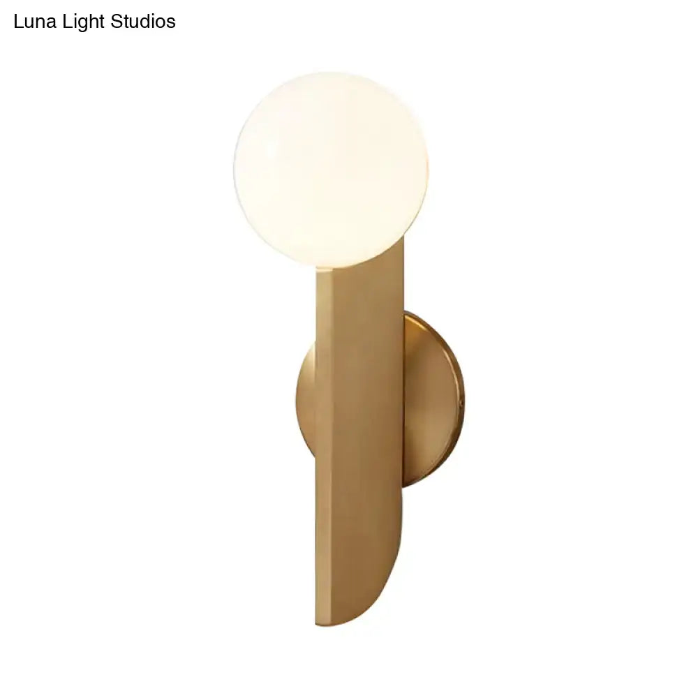 Minimalist gold mini globe wall sconce with a spherical frosted glass shade for modern bedroom lighting