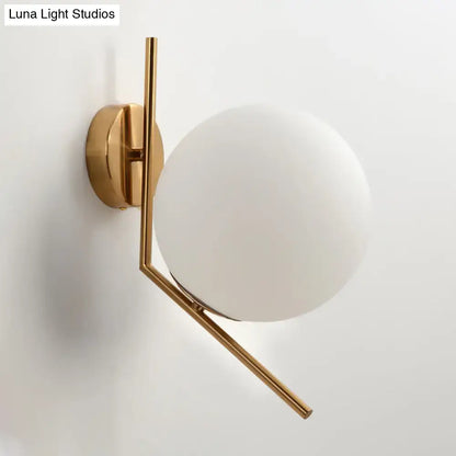 Minimalist gold mini globe wall sconce with frosted glass shade and geometric metal arms for bedroom lighting