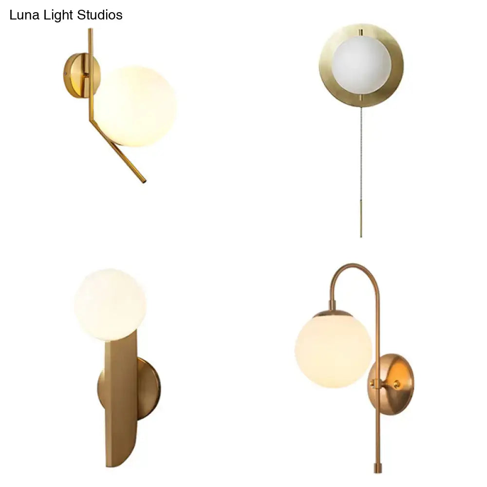 Minimalist gold mini globe wall sconce with frosted glass globe shades in a gold-toned modern bedroom light design