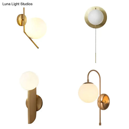 Minimalist gold mini globe wall sconce with frosted glass globe shades in a gold-toned modern bedroom light design