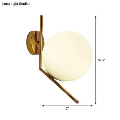 Gold mini globe wall sconce with sleek gold-toned metal arms and a frosted glass globe for minimalist bedroom lighting