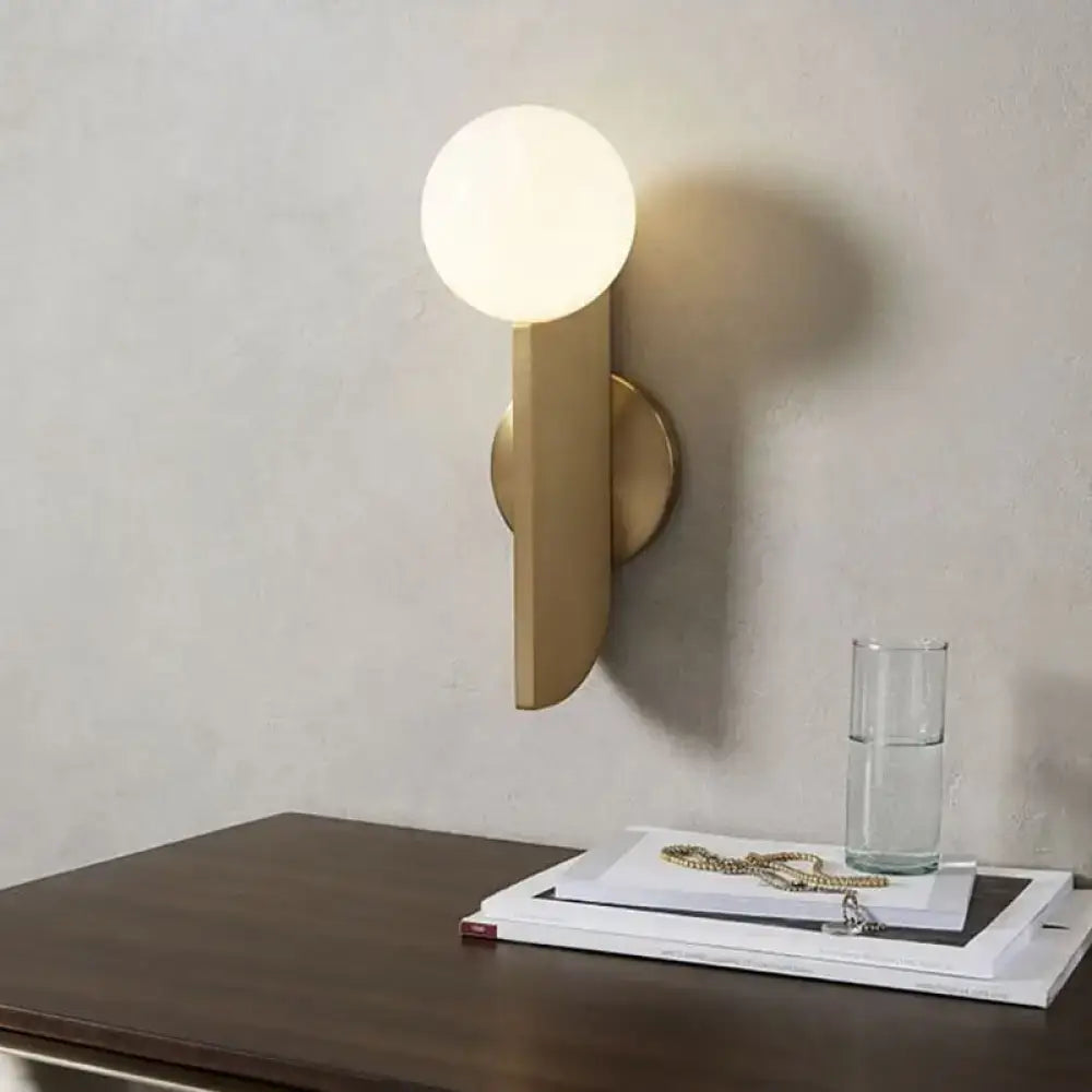 Minimalist gold mini globe wall sconce with spherical frosted glass bulb and geometric metal base for bedroom lighting