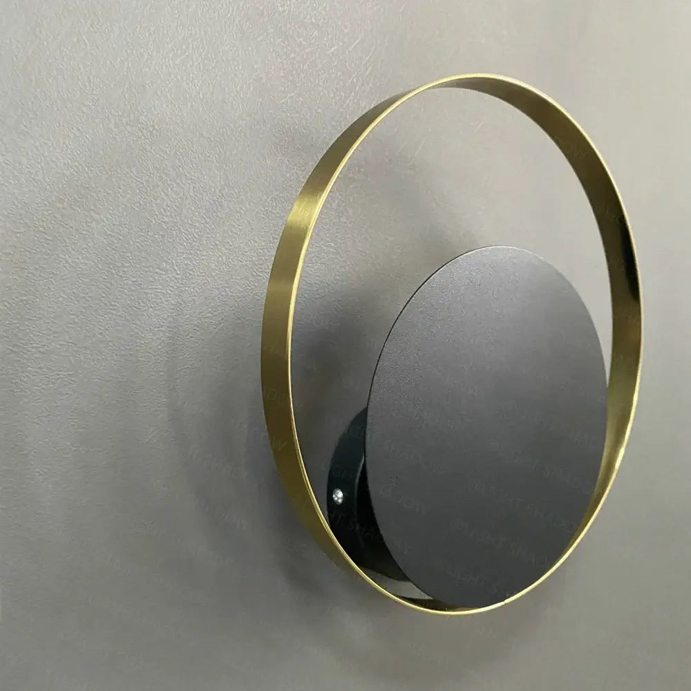 Minimalist gold nordic led wall sconce with sleek gold metal frame and matte black mirrored disc for bedroom lighting