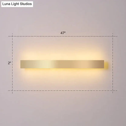 Modern minimalist gold plated led wall sconce with a sleek rectangular design and warm ambient lighting for living rooms