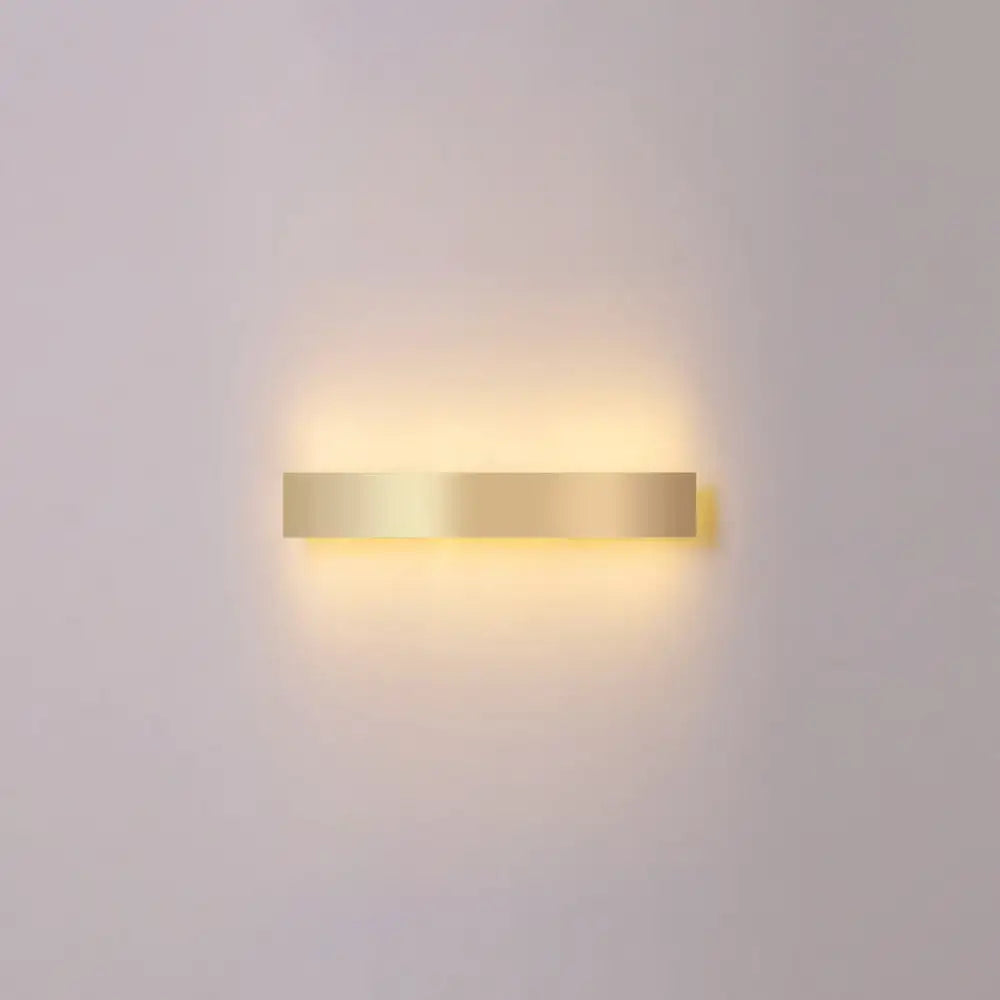 A minimalist gold plated rectangular led wall sconce with warm ambient light for living room and bar use