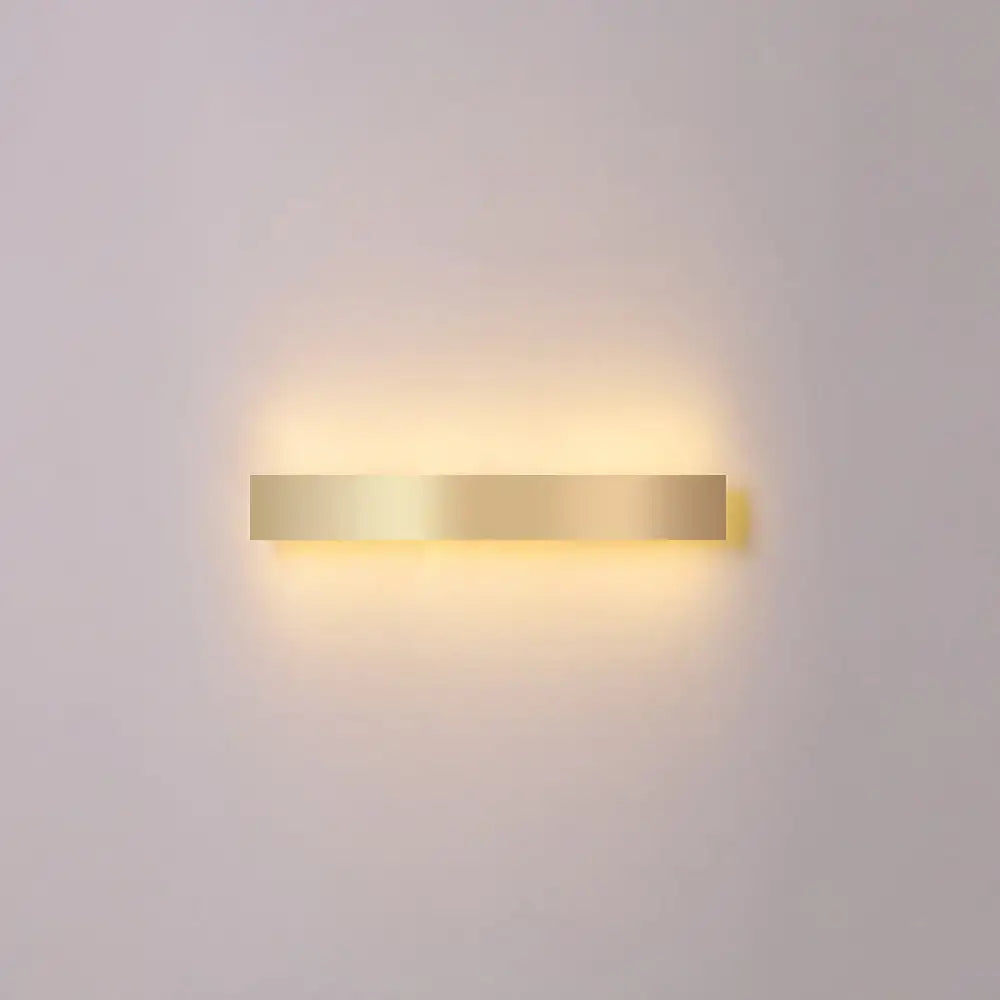 A sleek rectangular minimalist gold plated led wall sconce ideal for living room or bar lighting