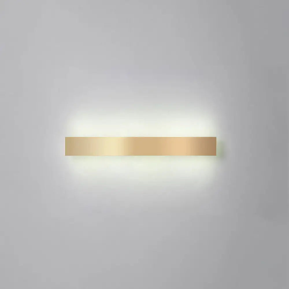 A sleek minimalist gold plated led wall sconce with a rectangular design for living room or bar lighting